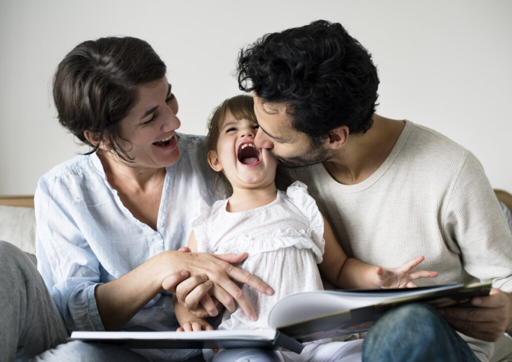 Happy parents laughing together with daughter